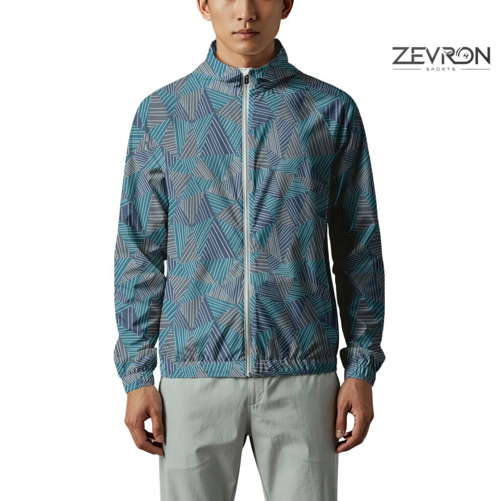 Man wearing a Zevron Sports windbreaker with a blue and grey geometric triangle pattern and white zipper.